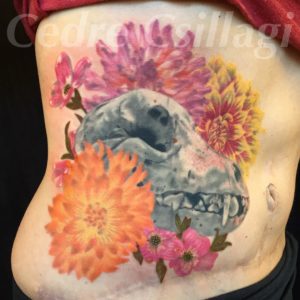  tattoo on my torso of a dog skull (grey scale) with colored flowers dogwood and dahlias